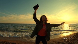实拍视频女子跟随手机音乐节奏伴着海边微风自由起舞