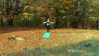 实拍视频一名女子在森林光照良好处铺设瑜伽垫进行运动