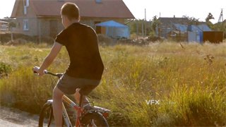 实拍视频年轻男孩在乡下田野间兴奋骑着自行车洋溢着快乐笑容