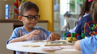 实拍视频幼稚园小朋友在专心致志思考如何拼接两块拼图