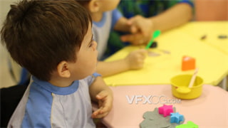 实拍视频老师在教室陪同小朋友用模具在橡皮泥印出形状