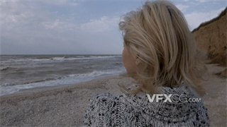 实拍视频女子孤单一人吹着海风坐在沙滩上看海