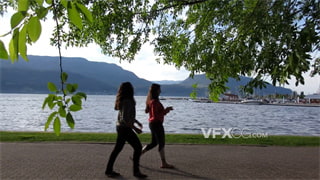 实拍视频在空气清新海边公园与朋边愉快交谈散步
