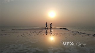 实拍视频航拍模式远景到近景切换拍摄夫妇在海中央平地上共舞