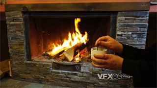 实拍视频在获取温暖燃烧火焰壁炉旁搅拌香醇美味咖啡