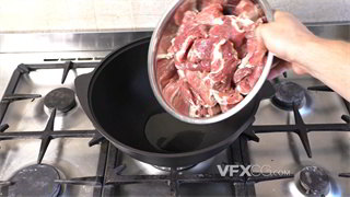 实拍视频将不锈钢盆里牛肉全部倒入油锅中焖煮