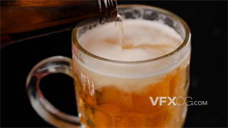 实拍视频在装满冰块透明玻璃杯中缓慢倒入啤酒冒出气泡