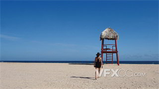 实拍视频在晴朗阳光明媚日子里女人在海滩上赤脚行走