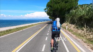 实拍视频跟踪拍摄专业自行车运动员在海边公路骑行