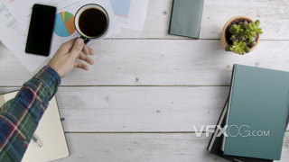 4K在工作和自习时举起桌上咖啡的视频