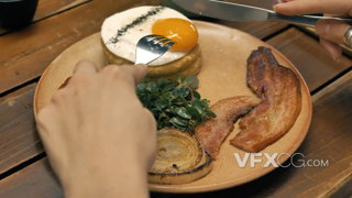 用刀叉品尝碟子里丰盛的诱人美味早餐的实拍视频