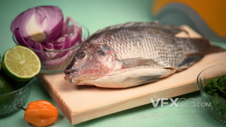 砧板上等待被做成美食的鱼和佐料的实拍视频