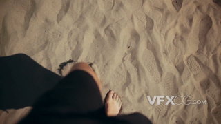 阳光明媚的天气下赤脚踩在沙滩上散步的实拍视频